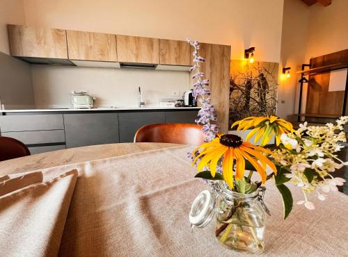 a vase filled with yellow flowers sitting on a table at Maso Valèr - Agritur in Tassullo
