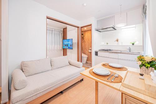 een woonkamer met een bank en een tafel bij Sheath Okachimachi Apartment Hotel in Tokyo