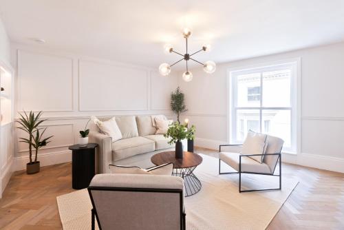Una sala de estar con un sofá blanco y sillas. en Apartment 2, en York