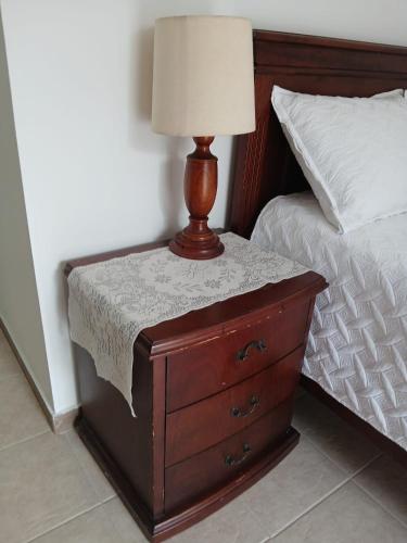 a bed with a dresser with a lamp on it at Tu Estancia en Cali - Valle del Lili in Cali