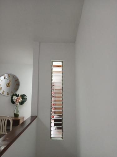a white wall with a clock and a shelf at Tu Estancia en Cali - Valle del Lili in Cali
