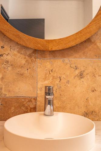 un lavabo blanc dans une salle de bain avec un miroir dans l'établissement Casetta Cavu, à Sainte-Lucie de Porto-Vecchio