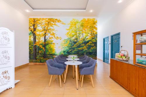 a dining room with a painting of trees at Lotus Luxury Villa Da Lat in Da Thien