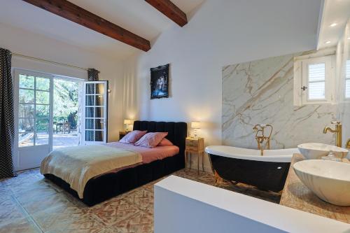 Postel nebo postele na pokoji v ubytování Mas provençal avec piscine chauffée, tennis, pétanque, vue mer, 20 min St Tropez