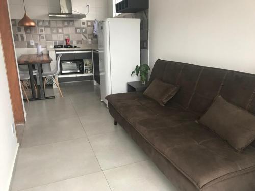 a living room with a brown couch and a kitchen at Apartmento com Jacuzzi para DOIS Bingen Petrópolis in Petrópolis
