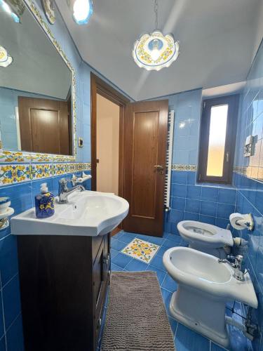a bathroom with two sinks and a toilet and a mirror at B&B Anna in Marigliano