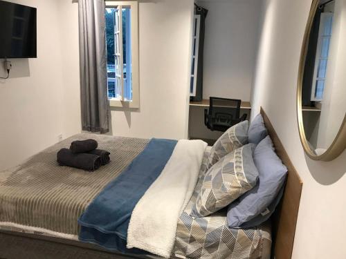 a bedroom with a bed and a mirror at Apartmento com Jacuzzi para DOIS Bingen Petrópolis in Petrópolis