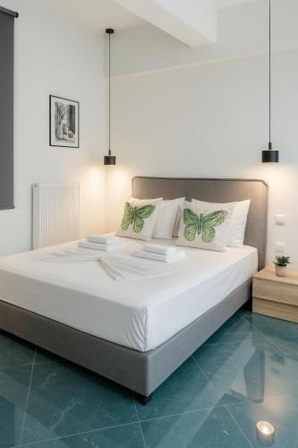 a bedroom with a large bed with white sheets and pillows at ATHENIAN Vibes in Athens