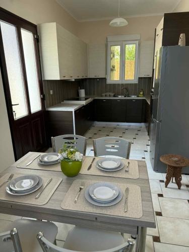 a kitchen with a table and chairs with plates andoverty at THALASSA Seafront in Vrontados