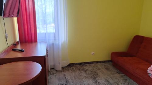 a room with a couch and a desk and a window at Rafa in Trzęsacz
