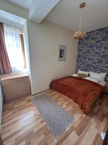 a bedroom with a bed and a brick wall at Casa Leone Hotel&Restaurant in Popova Shapka