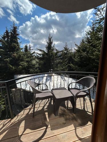a patio with two chairs and a table on a deck at Casa Leone Hotel&Restaurant in Popova Shapka