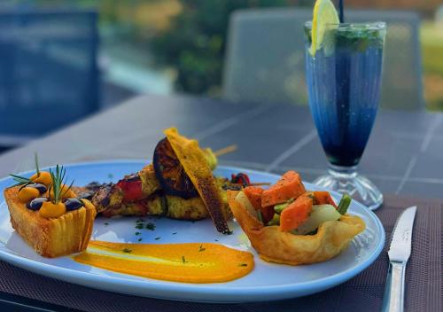 a plate of food on a table with a drink at Hôtel Fnideq Senator in Fnidek