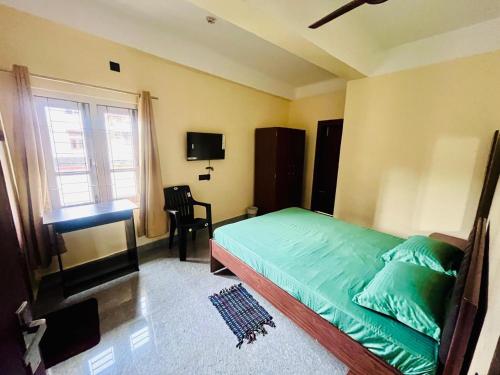 Un dormitorio con una cama y un escritorio y una ventana. en Octave Stay, en Guwahati