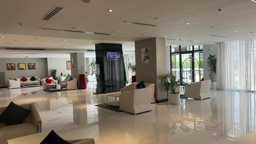 a lobby with couches and chairs in a building at Golden Tulip Al Khobar Suites in Al Khobar