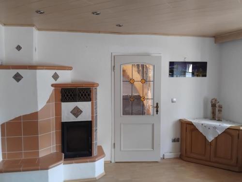 a living room with a stove and a door at Ferienhaus König in Kulmain