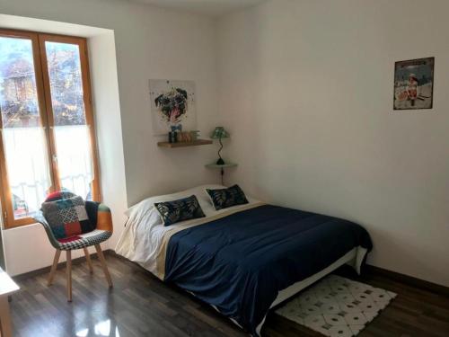 Studio cosy في سان مارتن فيسوبي: غرفة نوم بها سرير وكرسي ونافذة