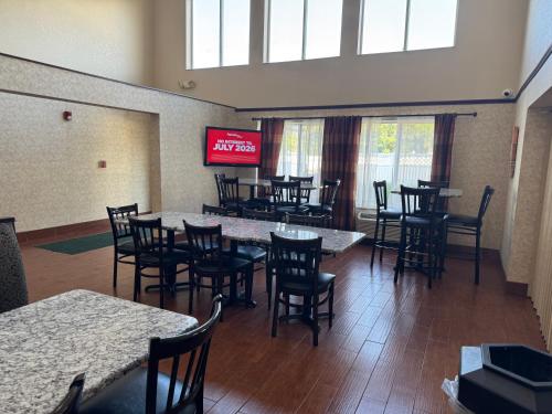 un restaurant avec des tables, des chaises et une télévision dans l'établissement Quality Inn & Suites Middletown - Franklin, à Franklin