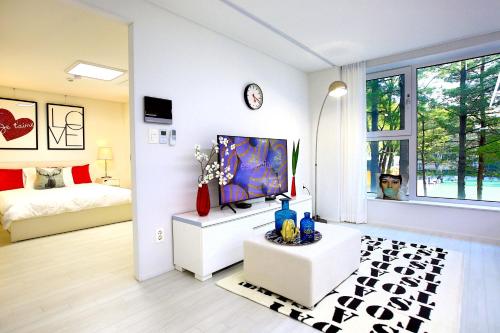 a living room with a tv and a bed in a room at Stay Park 1 in Goyang