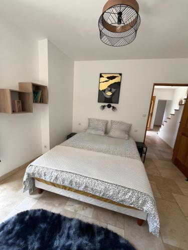 a bedroom with a large bed with a blue rug at Maison du soleil in Mérindol-les-Oliviers
