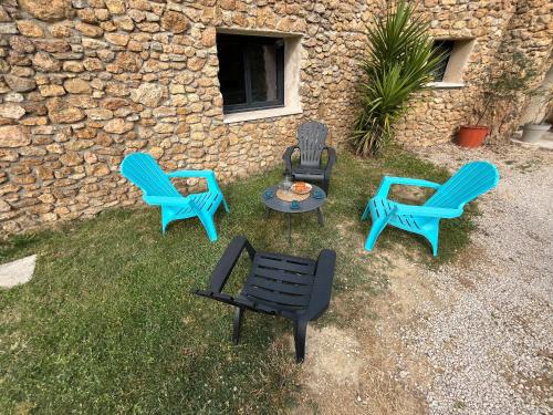 a group of chairs and a table in front of a building at Maison du soleil in Mérindol-les-Oliviers