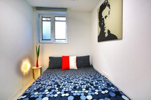 a small bedroom with a bed with a red pillow at Stay Park 1 in Goyang