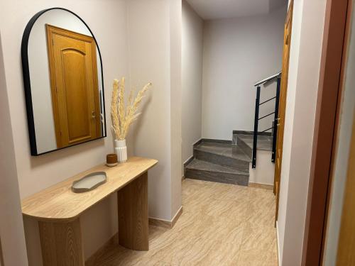 a hallway with a sink and a mirror and stairs at Casa Marsal - Proap Apartments in Encamp