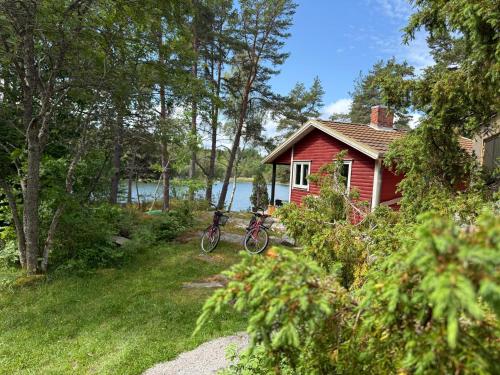 a bike is hanging off the side of a red house at Kustvy - En Destination intill Havet in Skärplinge