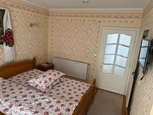 a bedroom with a bed and a window and a door at Casa Morarului in Bîrsana