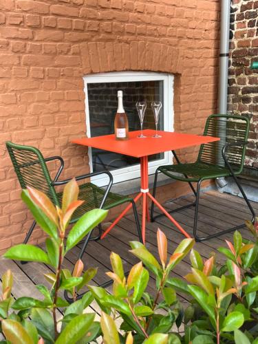 a red table with two wine glasses on a patio at Martha in Diksmuide
