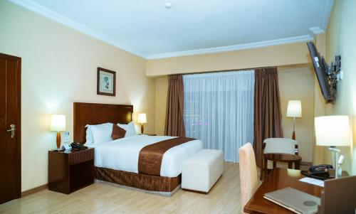 a hotel room with a bed and a desk at Capital Hotel and Spa in Addis Ababa