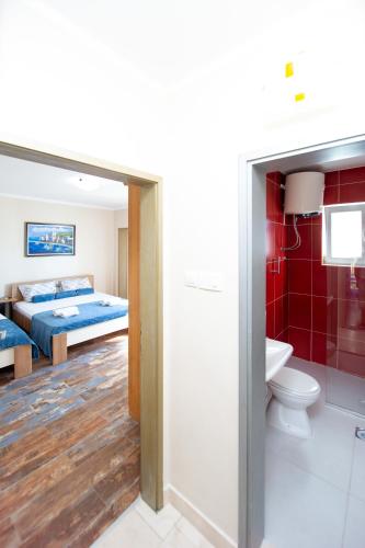 a bedroom with a bed and a bathroom with a toilet at ACIKA apartments in Rafailovici