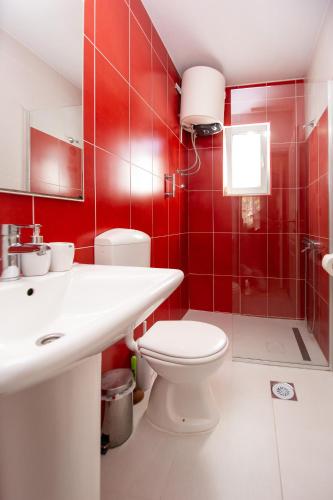 a red bathroom with a toilet and a shower at ACIKA apartments in Rafailovici