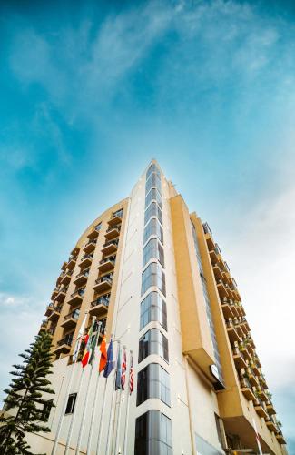 a tall building with flags on top of it at Capital Hotel and Spa in Addis Ababa