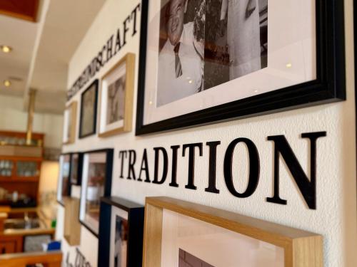 a wall with a tradition sign and pictures on it at Gasthof Ziegler Hotel & Restaurant in Lindau