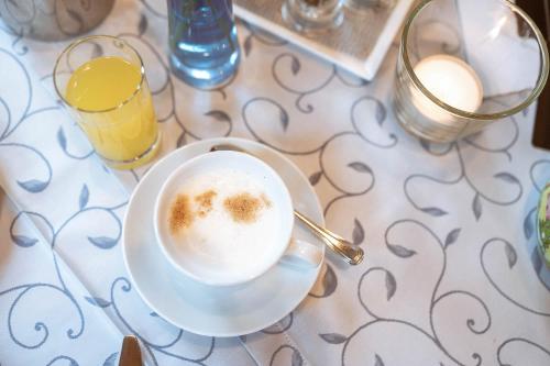 a cup of coffee sitting on top of a table at Hotel Bachschmied in Maria Alm am Steinernen Meer
