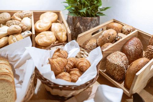 a table with baskets of different types of bread at Hotel Bachschmied in Maria Alm am Steinernen Meer