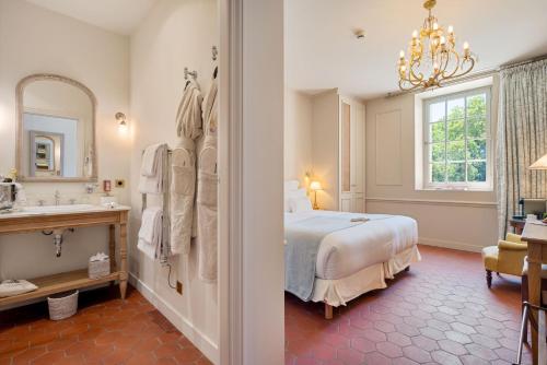 a bedroom with a bed and a sink and a mirror at Château de Fonscolombe in Le Puy-Sainte-Réparade