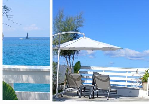 a patio with an umbrella and chairs and the ocean at B&B Il Gabbiano in Cittadella del Capo