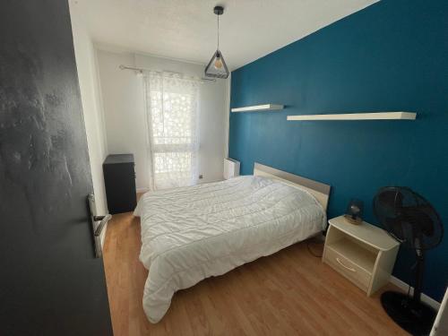 une chambre avec un lit et un mur bleu dans l'établissement Laetitia Touzé, à Rennes