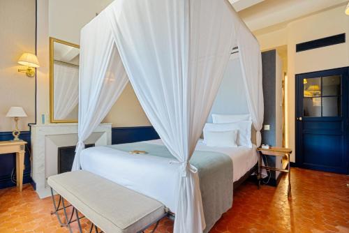 a bedroom with a bed with a canopy at Château de Fonscolombe in Le Puy-Sainte-Réparade