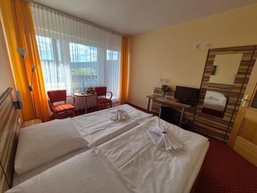 a large white bed in a hotel room at Panorama Hotel Oberwiesenthal in Kurort Oberwiesenthal