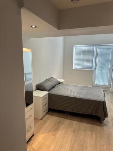 a bedroom with a bed and a dresser and a mirror at Comfort Rooms - Streatham Hill in London