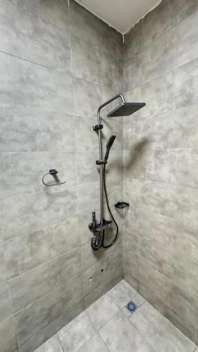 a shower with a shower head in a bathroom at Dahlia appartement- 2chambres- Lomé in Komé