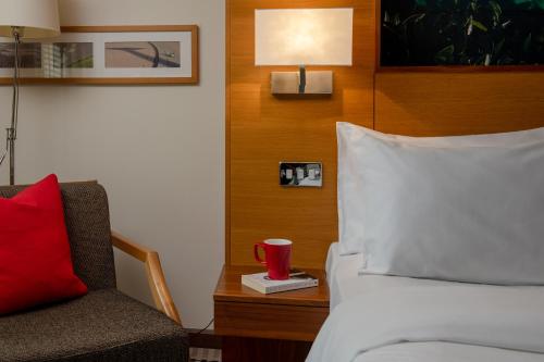 a bedroom with a bed and a chair and a red cup at Lodge at Bristol in Bristol