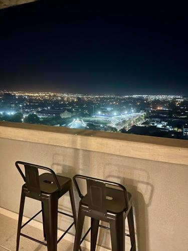 two chairs sitting on top of a balcony at night at ZOE PREMIUM Tucuman excelente ubicación luminoso, con PILETA!! in San Miguel de Tucumán