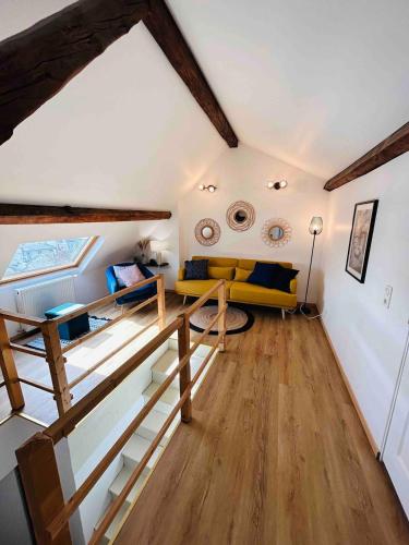 - un salon avec un canapé jaune et du parquet dans l'établissement Les Toits de Thillois Hypercentre, à Reims