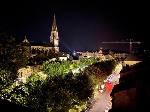 a view of a city at night with a church at Hotel Le Gambetta in Bergerac