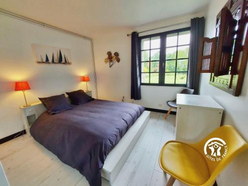 a bedroom with a large bed and a yellow chair at Millésime in Saint-Jean-sur-Mayenne