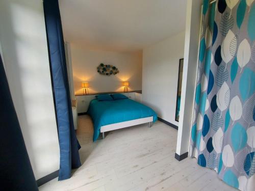 a bedroom with a blue bed and two lamps at Millésime in Saint-Jean-sur-Mayenne